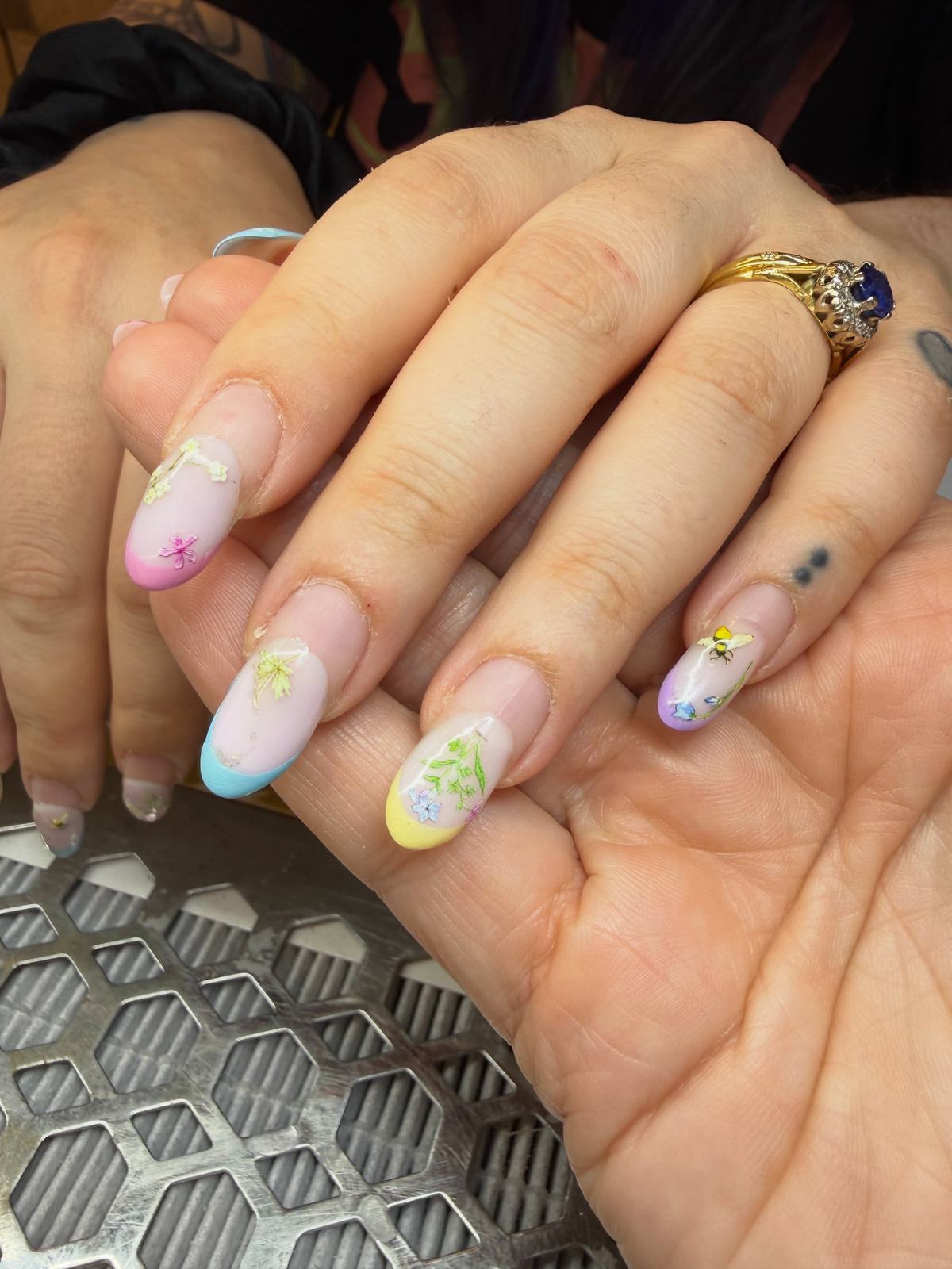 Pastel French tips in pink, blue, yellow and lilac with tiny hand-painted flowers